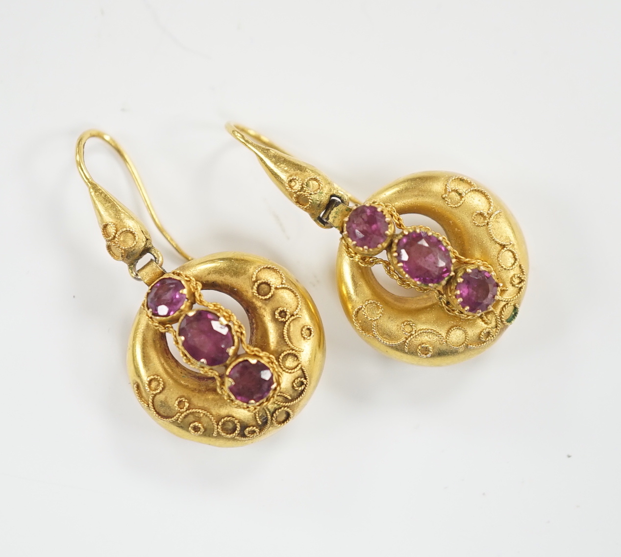 A pair of Victorian yellow metal canetile work and three stone garnet set drop earrings, overall 35mm, gross weight 4.1 grams.